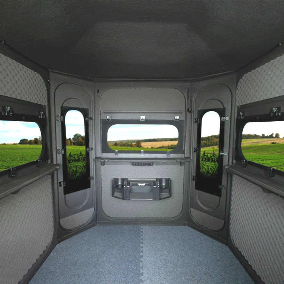 Interior of the 6'x6' Buck Palace Platinum 360 looking toward the front windows, showing the pre-installed gear console and the marine-carpeted floor.