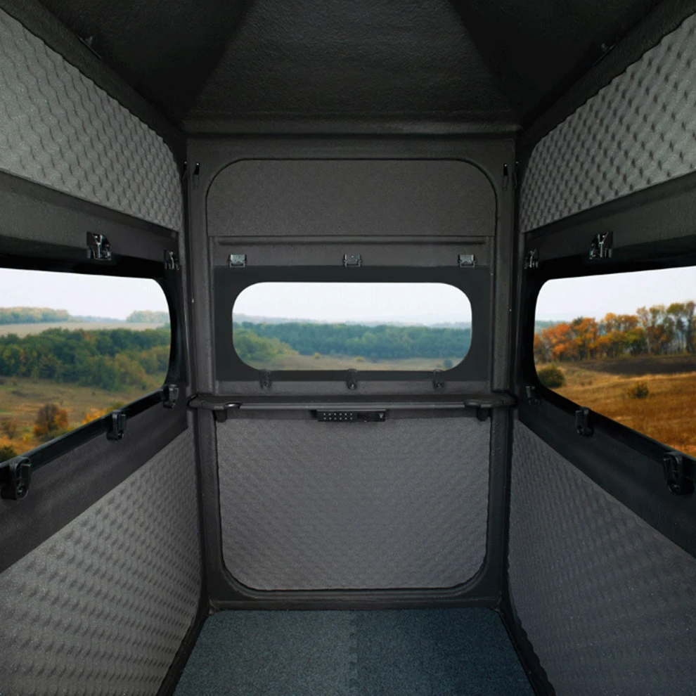 Interior of the 4'x4' Solo Hunter looking toward the front window, showing the shelf line and the marine-carpeted floor.